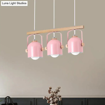 Pink metal pendant dome island light with wooden accents hanging from light wood bar in decorbites chandelier