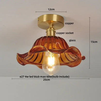 A warm amber glass flush mounted ceiling light with copper base and wavy design for modern bedroom use