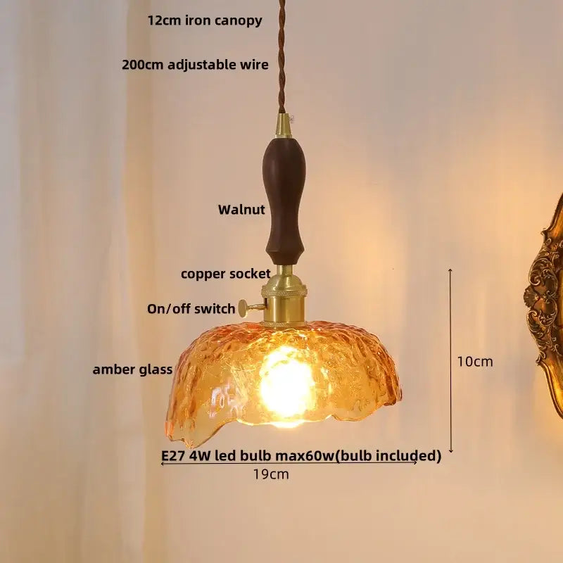 Modern pendant light with warm amber glass, dark walnut wood handle, and brass accents for dining room decor