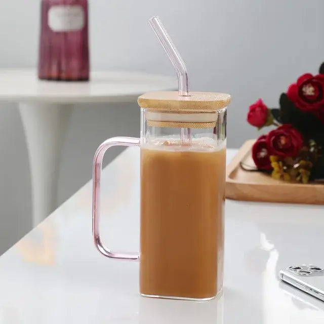 Modern square glass mug with clear rectangular body, pink handle, bamboo lid, and integrated clear straw for drinking