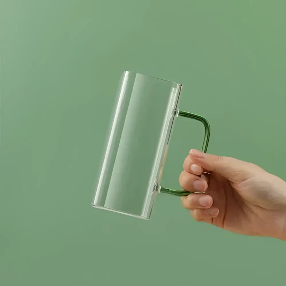 Modern green handle square glass mug with a clear glass body and sleek green metal handle for kitchen drinking use