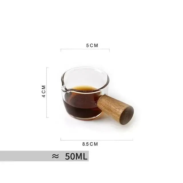 A clear square glass mug with a wooden handle filled with dark liquid for modern kitchen use