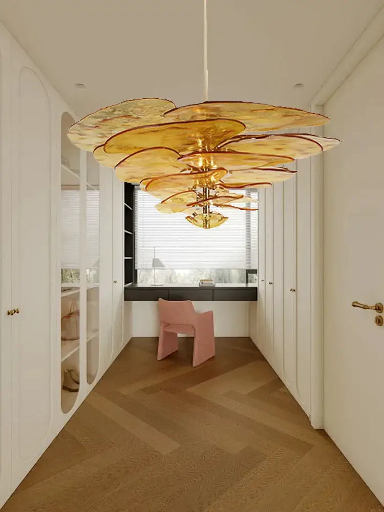 A golden layered petal glass chandelier with green leaf glass floral design hangs from the dining room ceiling