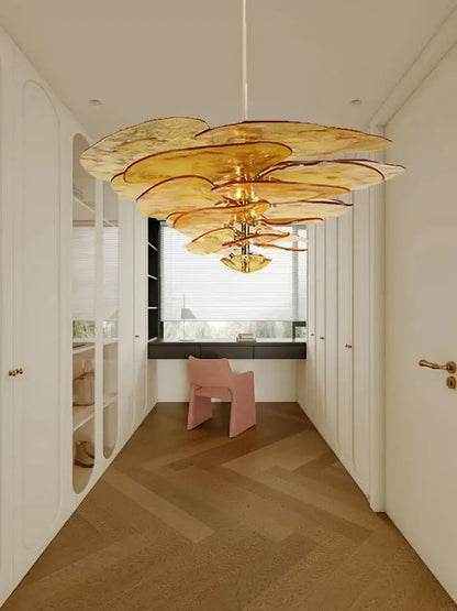 A golden layered petal glass chandelier with green leaf glass floral design hangs from the dining room ceiling