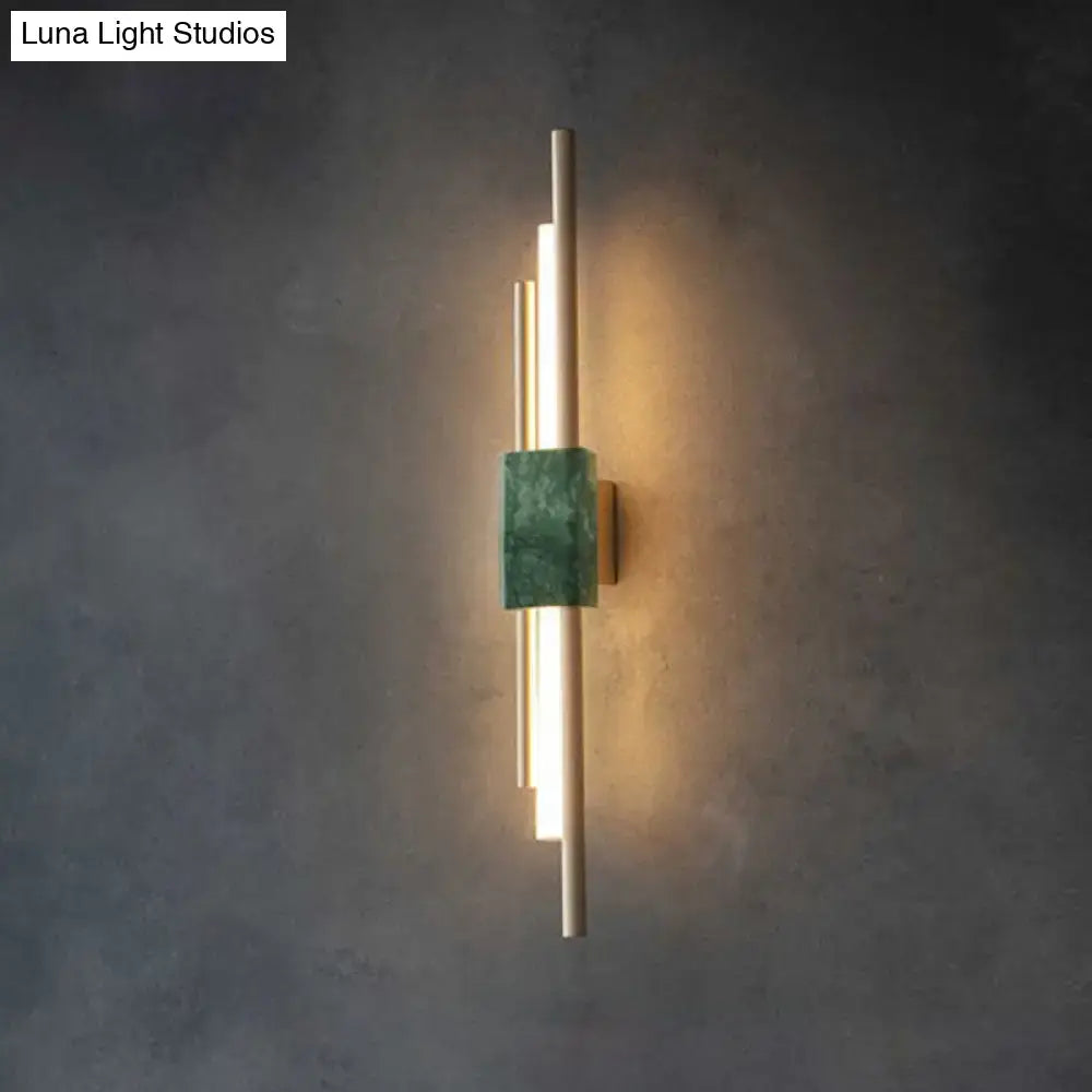 Modern wall sconce light featuring slender gold metal rods and a central green marble accent for bedroom decor