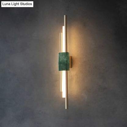 Modern wall sconce light featuring slender gold metal rods and a central green marble accent for bedroom decor