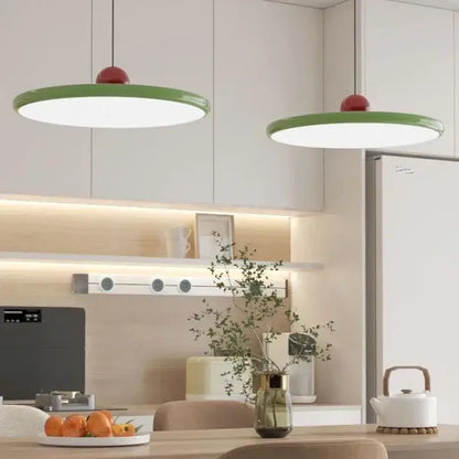 Modern green and red pendant light with graceful silhouette and led bulbs hanging from the dining room ceiling