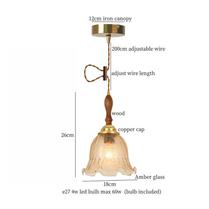 Modern green wave glass pendant light with warm amber glass, wooden stem, brass accents, and adjustable wire suspension