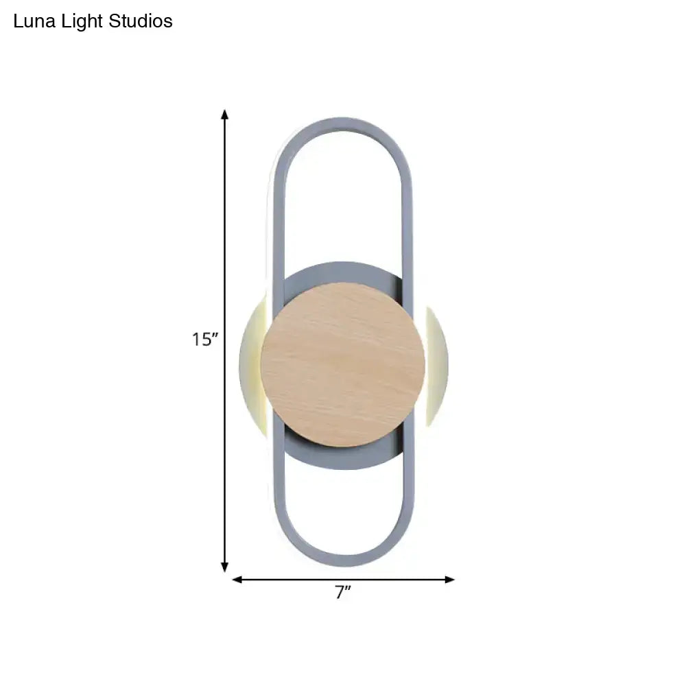 Modern grey and light wood led wall sconce with sleek metal frame circular wooden accent and soft ambient bedroom lighting