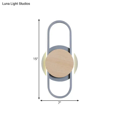 Modern grey and light wood led wall sconce with sleek metal frame circular wooden accent and soft ambient bedroom lighting