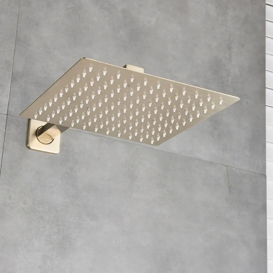 Modern hammered square wall mounted shower head with brushed gold finish and grid of evenly spaced nozzles