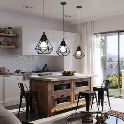 Three black modern industrial decorbites cage pendant lights hang above a wooden kitchen island pendant light decor