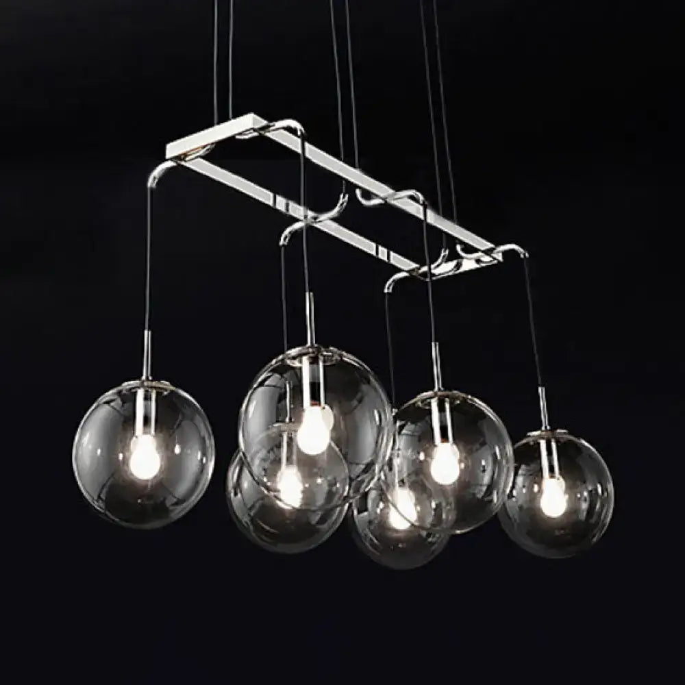 Modern chrome-finished pendant island lighting with five clear glass globe shades and smoke glass accents in nickel bronze
