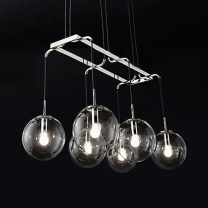 Modern chrome-finished pendant island lighting with five clear glass globe shades and smoke glass accents in nickel bronze