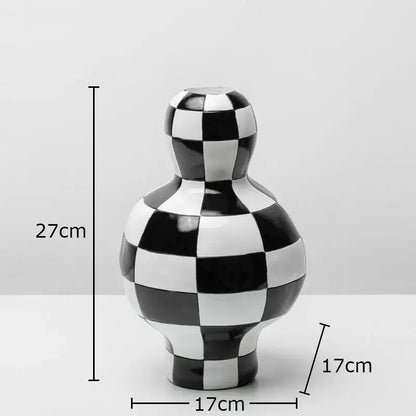 A glossy black and white checkered ceramic vase with a rounded body and narrow neck for modern room decor by decorbites black white