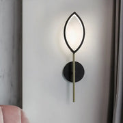 Modern leaf-shaped wall light with black frame and gold finish brass stem for living room use