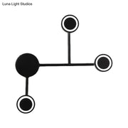 Modern led black wall sconce coat rack with four circular warm white hooks mounted on a minimalist black wall