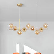 Gold-toned decorbites 9-light modern chandelier with amber glass globe bulbs and central head ring chandelier design