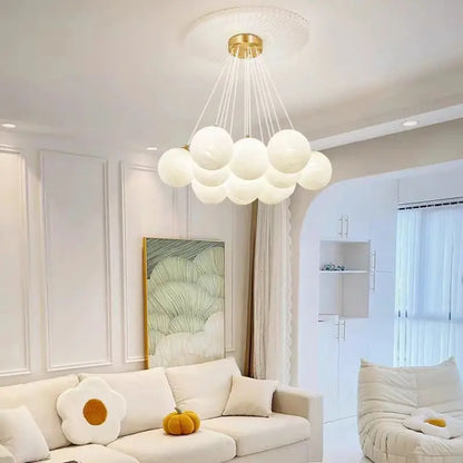 A modern cloud-shaped luxury led pendant lamp with milk white glass balls and gold fixture for living room lighting