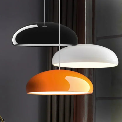 Three modern black white and orange round aluminum pendant lights with glossy dome shades for dining table decor