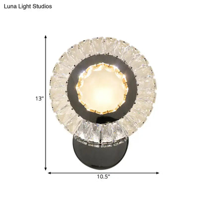 Modern led wall mount lamp with clear rectangle cut crystals and black circular base featuring warm glowing faceted crystals