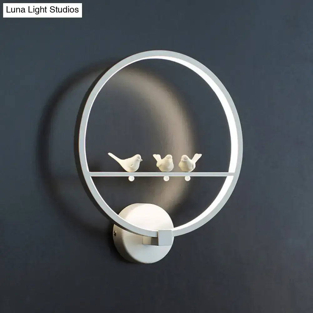 Modern led white wall lamp with sleek circular frame and three ceramic birds on integrated horizontal bar for bedroom