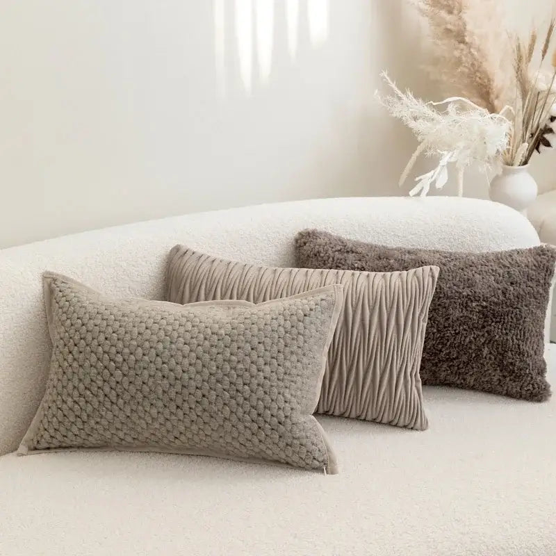 Three beige textured throw pillows with knitted and pleated patterns on decorbites light grey coffee cushion covers