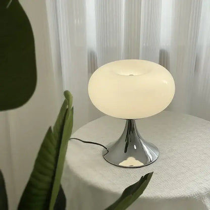 Modern lime green resin stool with a cream-colored translucent glass desk lamp and polished chrome base from decorbites glass desk collection