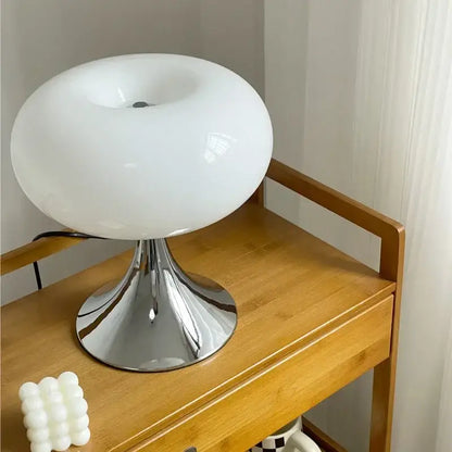 A sleek white frosted glass mushroom-shaped decorbites glass desk lamp with a polished chrome pedestal base