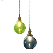 Two spherical decorbites bubble glass ball pendant lights in lime green and teal blue with twisted copper cords