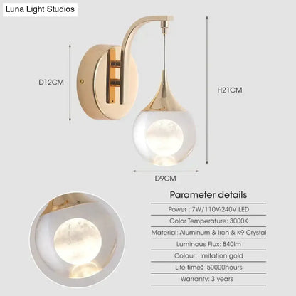 Modern luxurious crystal led wall sconce with a gold curved lamp and teardrop glass globe for bedroom lighting