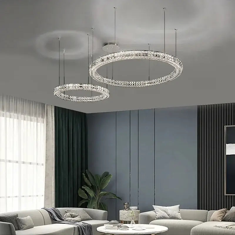 Two elegant crystal led chandelier circular fixtures with chrome decorbites finish hang in a dining room setting