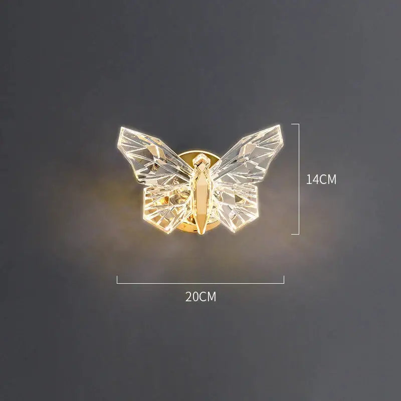A modern luxury crystal butterfly wall lamp with faceted wings and gold-toned body for elegant bedroom decor