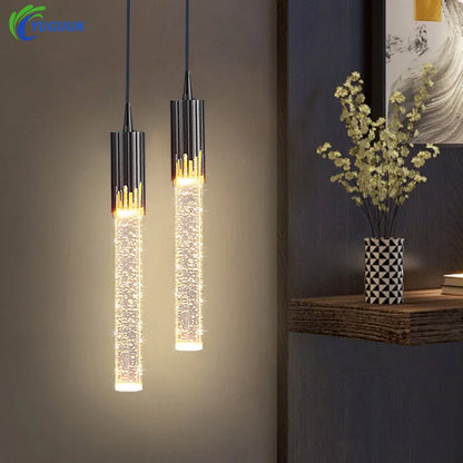 Two modern luxury crystal pendant lamps with black cylindrical tops and golden accents for living room lighting