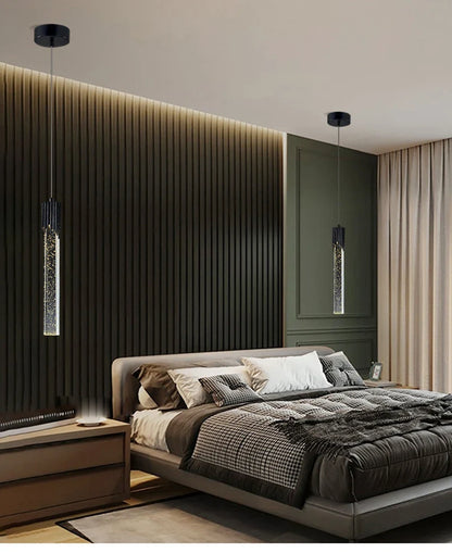 Modern luxury crystal pendant lamps with black finish and sparkling vertical glass tubes hanging above the bed