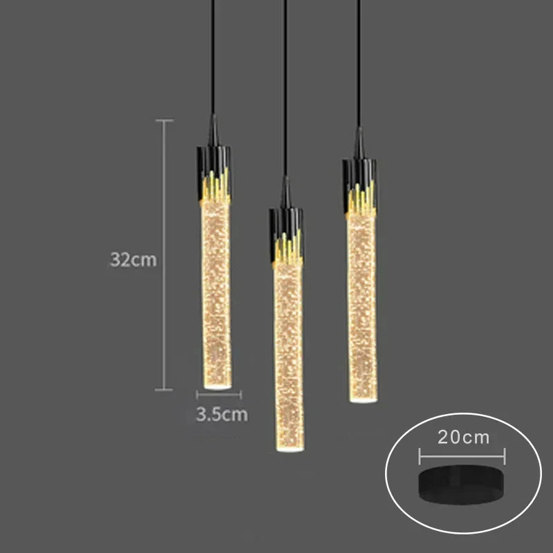 Three modern black and gold cylindrical crystal pendant lamps with sparkling golden glass interiors for home decor