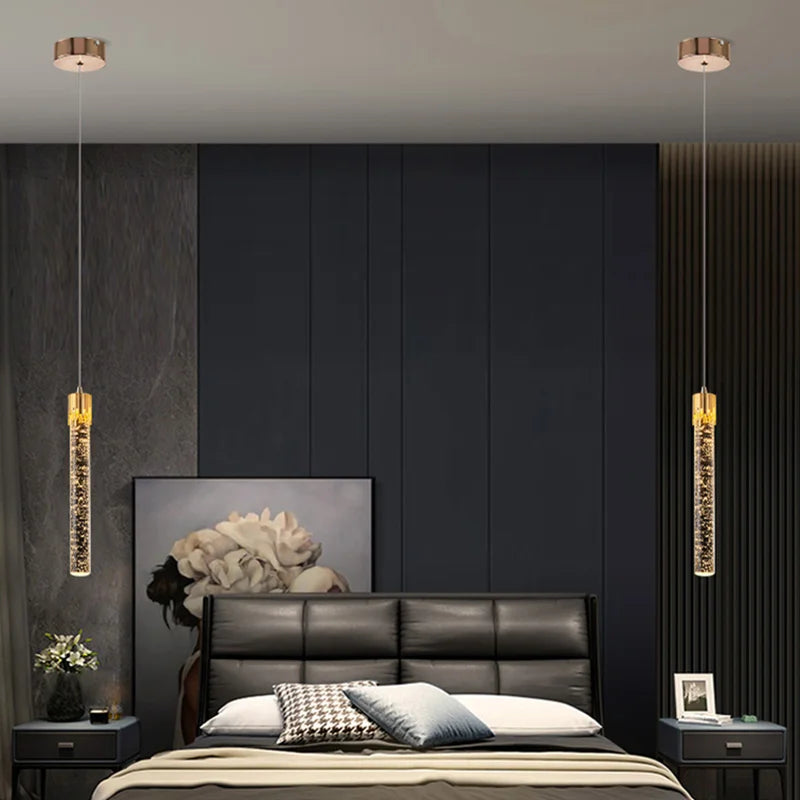 Two gold-toned cylindrical pendant lamps with crystal interiors for modern luxury home decor lighting