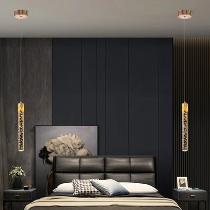 Two gold-toned cylindrical pendant lamps with crystal interiors for modern luxury home decor lighting