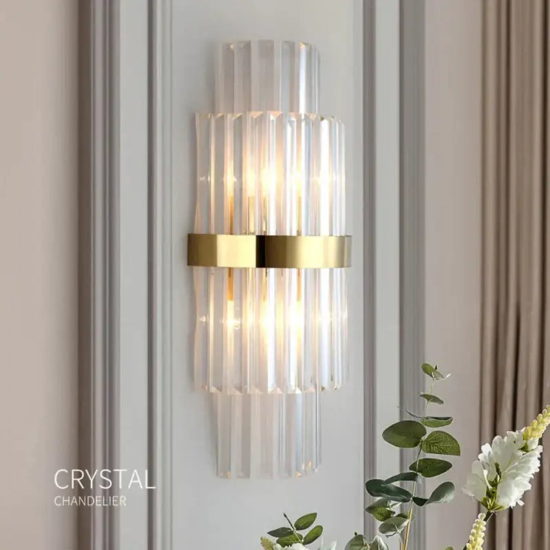 Elegant wall lamp with vertical crystal rods and polished gold band a decorbites crystal led wall lamp for bedroom decor