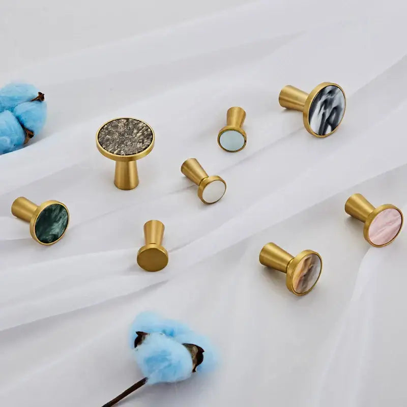 Modern marbled stone and decorbites brushed gold towel hook with circular stone inlays in varied natural patterns and colors