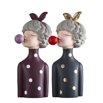 Modern maroon and silver bubble gum girl statue featuring two figurines with gray curly hair and colorful polka-dot outfits