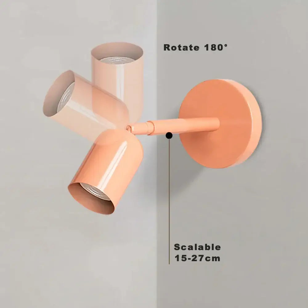 Modern matte pastel peach wall sconce with three adjustable gu10 led cylindrical heads for bedroom lighting