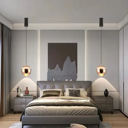 Modern gray upholstered bed with tufted headboard and layered bedding illuminated by matte ball pendant lights