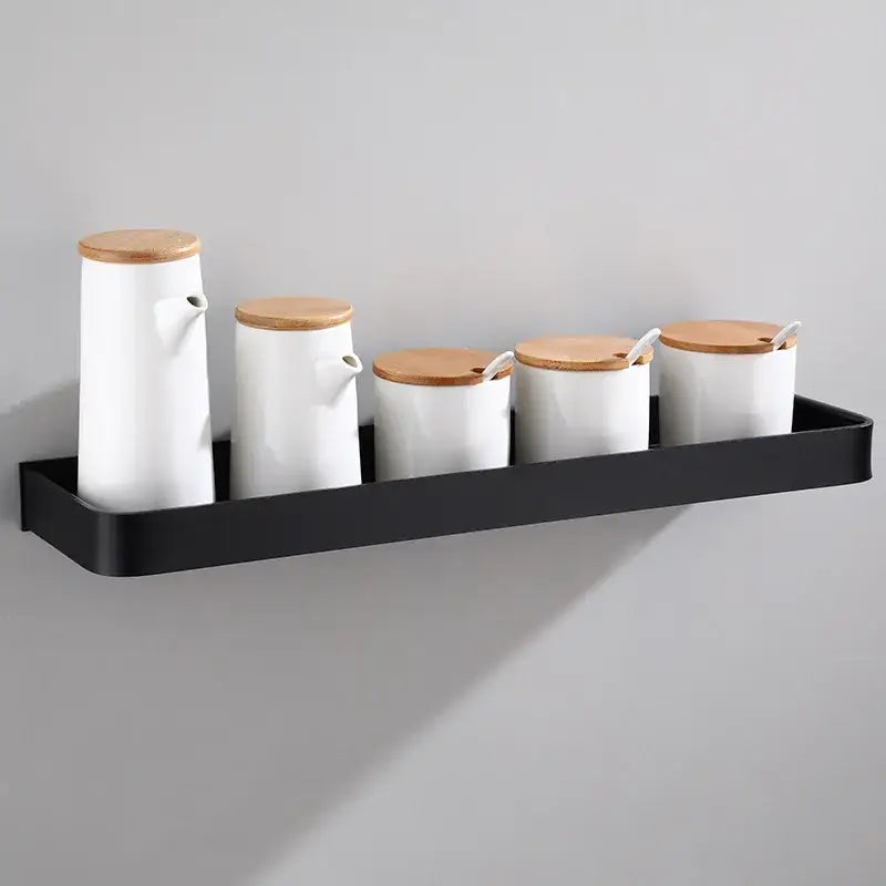 Set of five white ceramic spice jars with bamboo lids on a decorbites black aluminum corner shelf bathroom storage holder