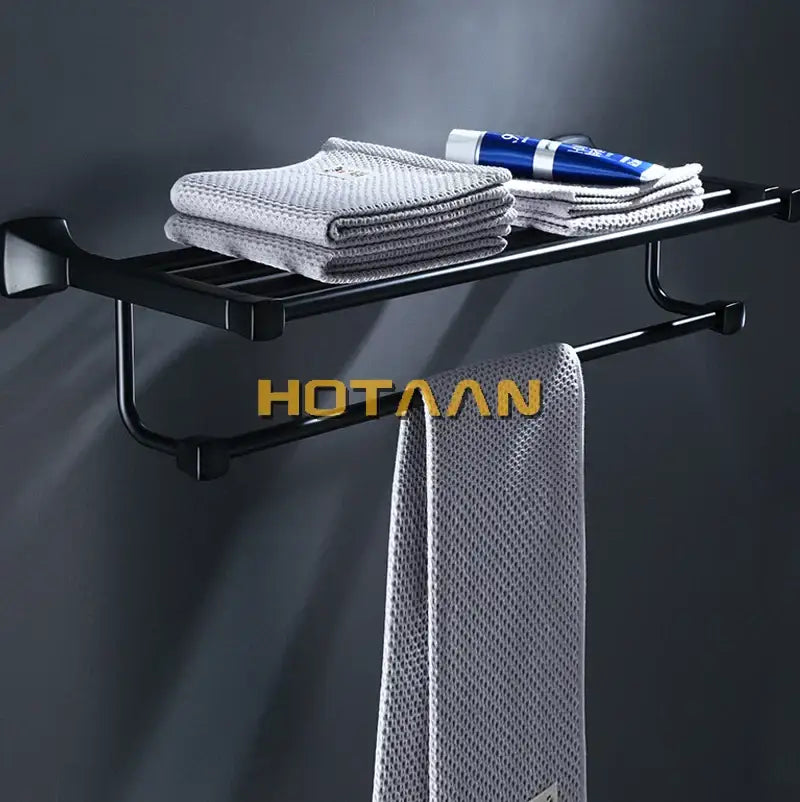Modern matte black aluminum towel rack with hook bathroom shelf holding gray towels and a blue tube decorbites black aluminum