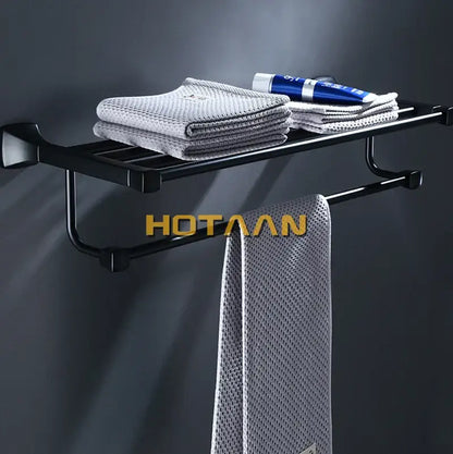 Modern matte black aluminum towel rack with hook bathroom shelf holding gray towels and a blue tube decorbites black aluminum