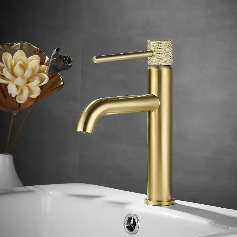Modern matte black basin faucet with gold-toned brushed gold single-handle and textured knurled knob by decorbites