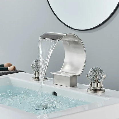 Modern matte black bathroom faucet set featuring a sleek curved metallic waterfall faucet with crystal-encrusted handles