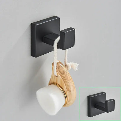 Modern matte black bathroom hardware set showing a black matte square double hook holding a wooden and white soap brush