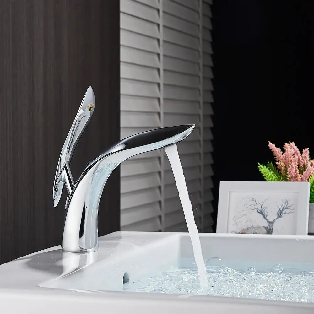 Modern chrome-finished decorbites brass washbasin faucet with sleek sculptural design and single spout handle for bathroom use